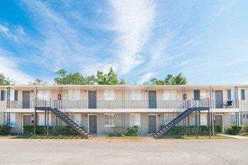 Exterior of two-story building with metal stairs.